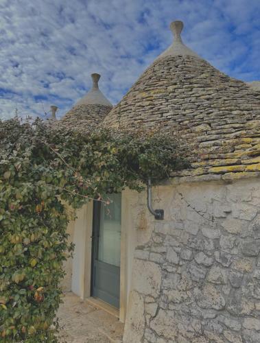 a stone building with a window and a ivy at Masseria La Mandra in Noci