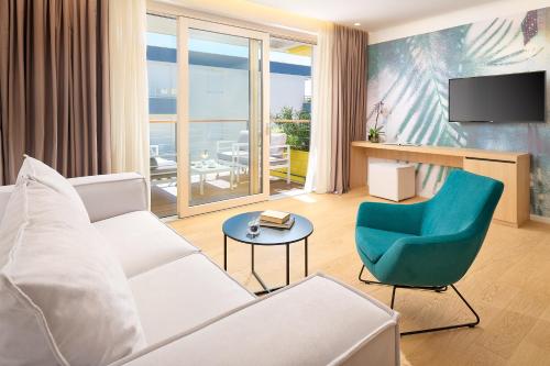 a living room with a white couch and a blue chair at Amphora's Garden in Split