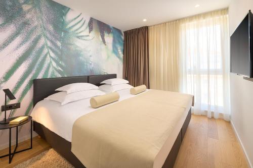a bedroom with a large bed with white pillows at Amphora's Garden in Split