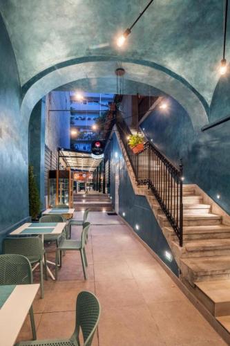 a restaurant with stairs and tables and chairs at Cherry Apartman in Eger