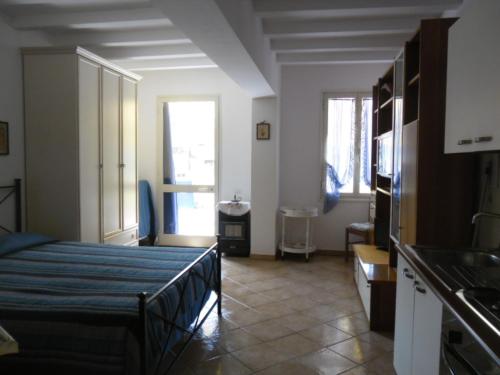 a room with a bed and a kitchen with a sink at Appartamenti Claudia Rio in Rio Marina