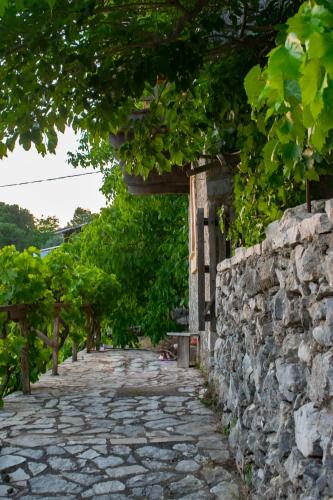 a stone path next to a stone wall at Arcadianis lakeview villa at Psari Arkadias in Psárion