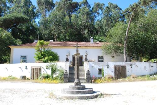 a white house with a fountain in front of it at Quinta do Brejo - Turismo Equestre in Mafra
