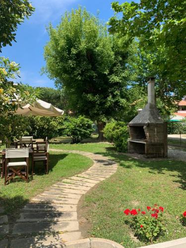 a garden with a table and a stone pathway at Hotel President in Cervia