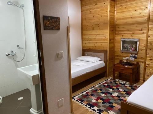 a small bathroom with a bed and a sink at Ahmetaj Guest House in Gjirokastër