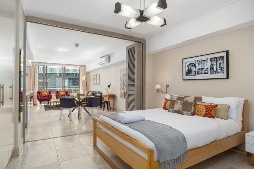 1 dormitorio con 1 cama y sala de estar en Canal Quays Apartments, en Ciudad del Cabo