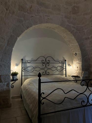 ein Schlafzimmer mit einem Bett in einer Steinmauer in der Unterkunft Masseria La Mandra in Noci