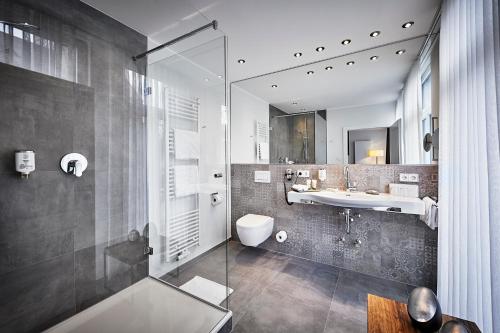 ein Bad mit einem Waschbecken und einem WC in der Unterkunft Hotel Störmann in Schmallenberg