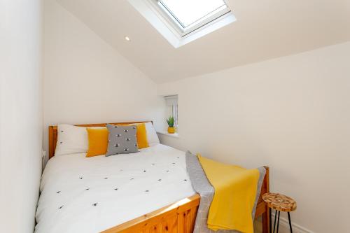 The Bs Hive, Modern, stylish, 2 bedroom house, in Harrogate centre في هاروغايت: غرفة نوم صغيرة مع سرير مع منور