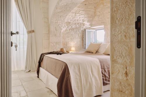 a bedroom with a bed with a stone wall at 1783 Dimora d'Epoca in Locorotondo