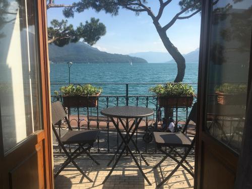 a balcony with a table and chairs and a view of the water at Residence Domaso - Esperienza in Centro Storico "Casa del Dottore" in Domaso