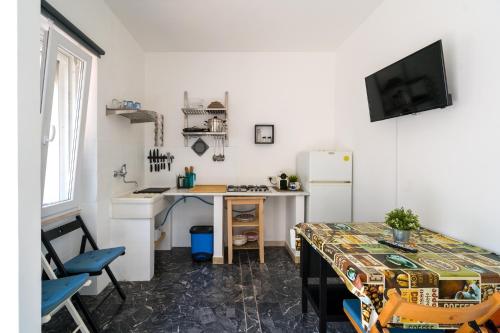 a small kitchen with a table and a refrigerator at Borgo Canneto in Rodi Garganico