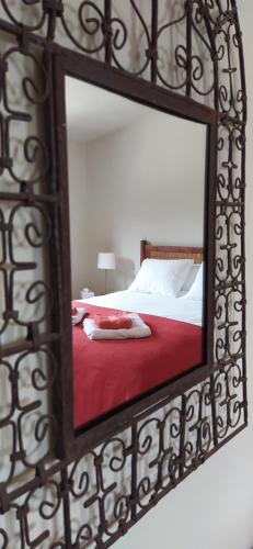 a mirror reflecting a bed with a red blanket at Finca Las Morenas in Yunquera
