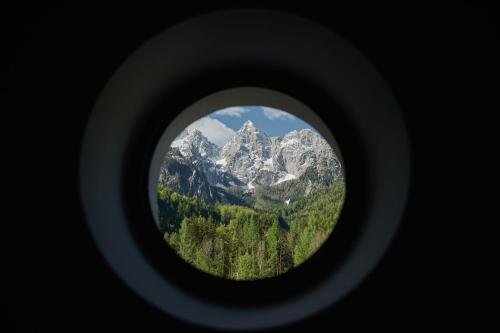 a view of a mountain through a round window at Triangel Boutique Hotel in Kranjska Gora