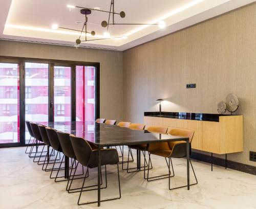 a dining room with a black table and chairs at Hotel Ilunion San Mamés in Bilbao