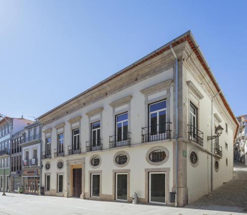 a large white building with balconies on a street at Vignette Collection - Casa da Companhia, an IHG Hotel in Porto