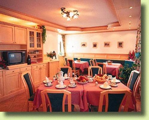 a dining room with a table with red table cloth at Pension Linortner in St. Wolfgang