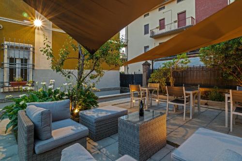 a patio with chairs and a table and chairs at Casa Mirko - B & B con stazione ricarica auto elettriche parcheggio privato auto moto biciclette in Arezzo