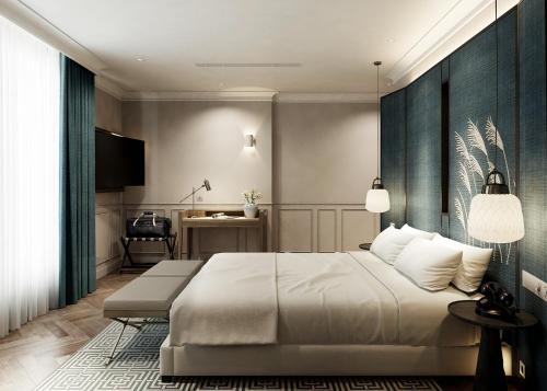 a bedroom with a large white bed and a desk at La Passion Hanoi Hotel & Spa in Hanoi
