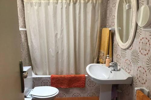 a bathroom with a sink and a toilet and a mirror at Casa familiar decimonónica con mucho encanto in Sant Feliu de Guíxols