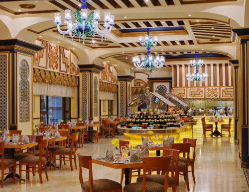 a dining room with tables and chairs and chandeliers at Dar Al Tawhid Intercontinental Makkah, an IHG Hotel in Mecca