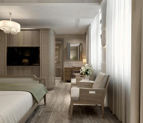 a bedroom with a bed and a chair and a desk at La Passion Hanoi Hotel & Spa in Hanoi