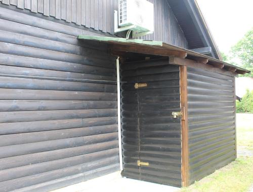 a wooden building with a door on the side at Hiška Čatež in Brežice