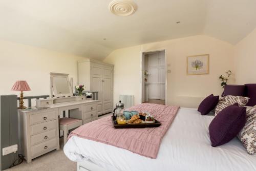 a bedroom with a bed with a tray of fruit on it at Chirk Cottage at Hill House Farm Cheshire in Tarporley