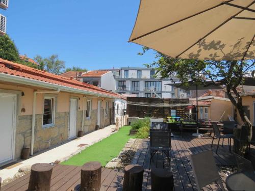 een patio met een parasol en een tuin met gras bij Ruby Charm Houses 2 AL in Porto