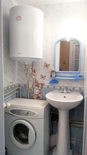 a bathroom with a washing machine and a sink at Deribasovskaya 16 in Odesa