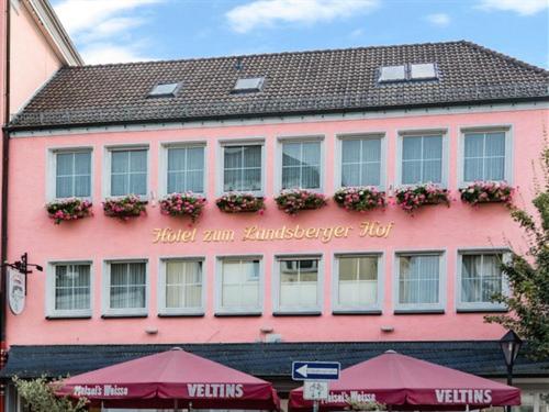 a pink building with a sign that reads hotel am hamburger inn at Zum Landsberger Hof in Arnsberg