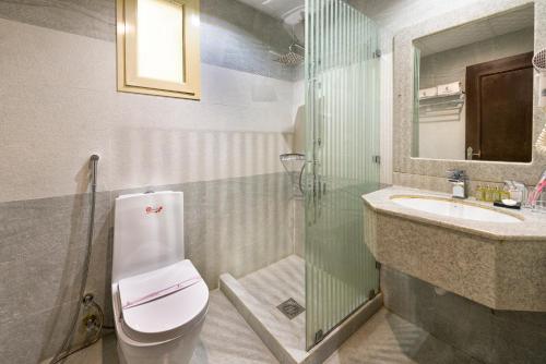 a bathroom with a toilet and a sink and a shower at Elite Al Hamra - Al Cornich in Jeddah