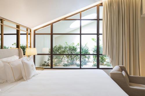 a bedroom with a large bed and a large window at Casa da Companhia Hotel & Spa, Vignette Collection by IHG in Porto