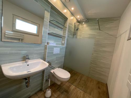 bagno con lavandino, servizi igienici e specchio di Spreeparadies-Semisch a Markische Heide