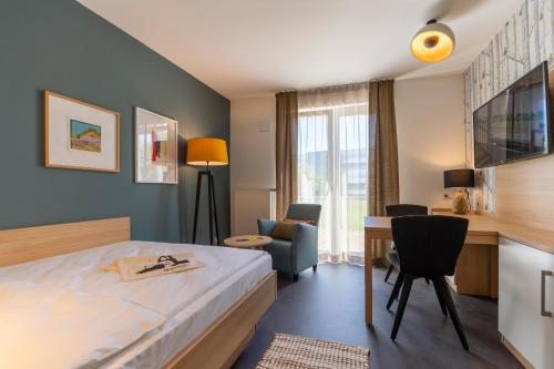 a hotel room with a bed and a desk at KONCEPT HOTEL Neue Horizonte in Tübingen