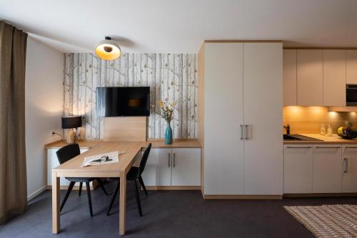 a kitchen and dining room with a table and cabinets at KONCEPT HOTEL Neue Horizonte in Tübingen
