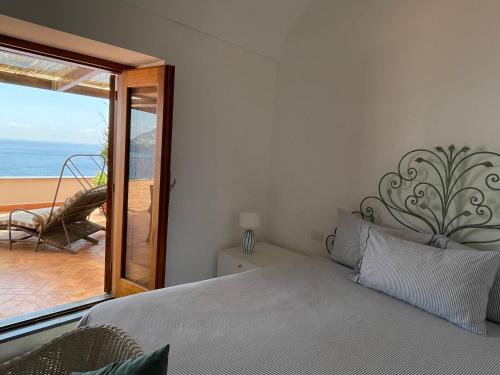a bedroom with a bed and a view of the ocean at Suite Antimo - Casa Scibetta in Positano