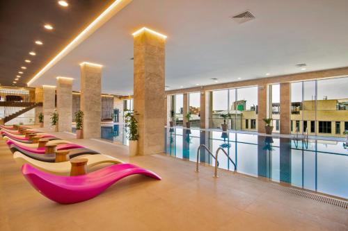 a pool with a row of chairs next to a swimming pool at Holiday Inn Yerevan - Republic Square by IHG in Yerevan