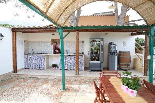 a patio with an outdoor kitchen with a table and chairs at Villa I Due Pini in San Vito lo Capo