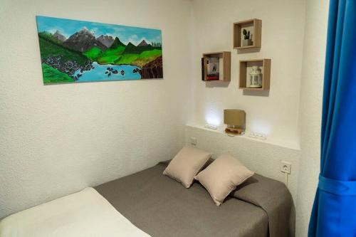 Cette petite chambre dispose d'un lit et d'une peinture murale. dans l'établissement PROBER_NEVADA II, au Pas de la Case