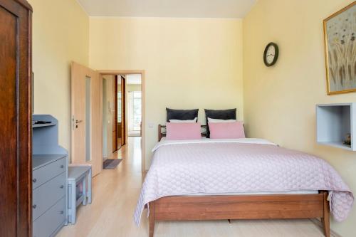 a bedroom with a large bed with pink pillows at Spacious apartment with cozy balcony by URBAN RENT in Vilnius