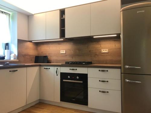 a kitchen with white cabinets and a black oven at Holiday Home Anja in Bohinj