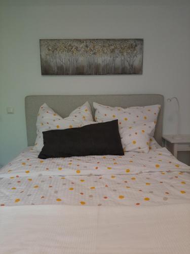 a bed with polka dot sheets and a black pillow at Waldurlaub Klingelborn im Sauerland in Balve