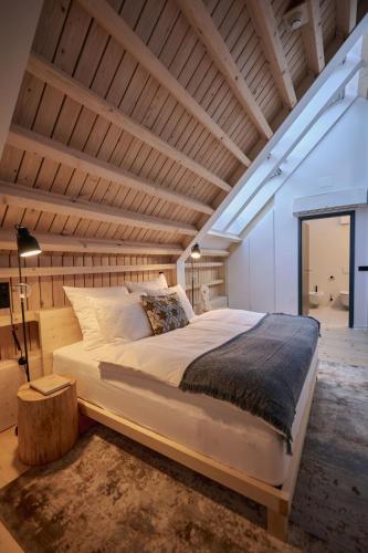 a large bed in a room with a wooden ceiling at Triangel Boutique Hotel in Kranjska Gora