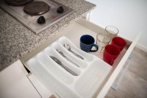 a white tray with utensils on top of a kitchen counter at Edificio Pampa II in Añelo