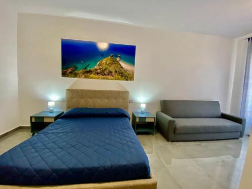 1 dormitorio con 1 cama azul y 1 sofá en B&B DEL CORSO, en Ascea