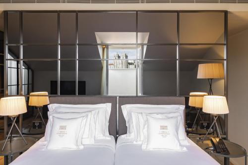 a bedroom with a bed with white pillows at Casa da Companhia Hotel & Spa, Vignette Collection by IHG in Porto