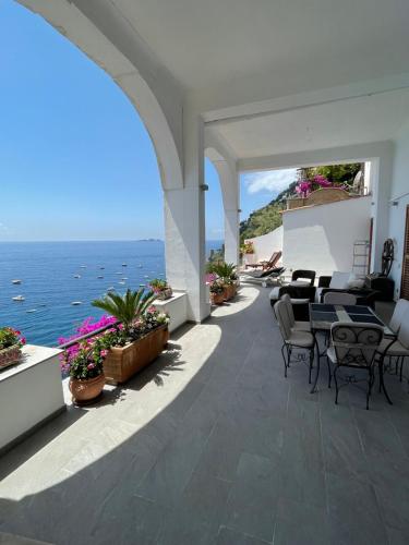 a patio with tables and chairs and the ocean at Casa Antioco Original in Positano