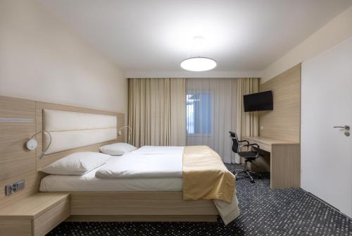 Dębno PolskieにあるHotel Mariaのベッドとデスクが備わるホテルルームです。