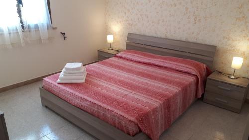 レウカにあるCasa Vacanza Leucaのベッドルーム1室(赤いベッド1台、ナイトスタンド2台付)